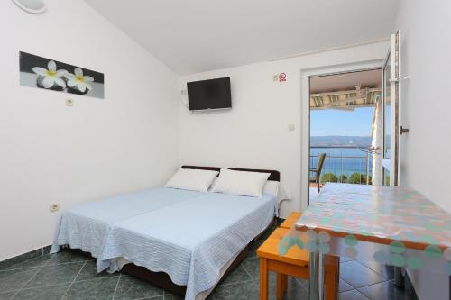 sypialnia z łóżkiem i widokiem na ocean w obiekcie Apartments by the sea Duce, Omis - 2737 w Duće