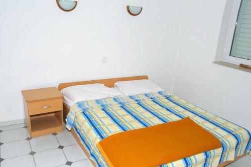 - une petite chambre avec un lit et une table de nuit dans l'établissement Apartments with WiFi Omis - 2757, à Omiš