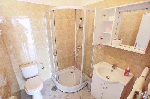 a bathroom with a shower and a toilet and a sink at Apartments by the sea Mimice, Omis - 2774 in Mimice
