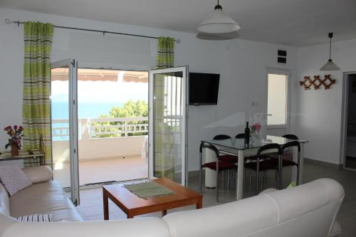 a living room with a couch and a table with a balcony at Apartments by the sea Mimice, Omis - 2774 in Mimice