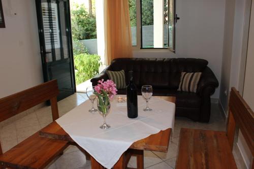 a table with a bottle of wine and flowers on it at Apartments by the sea Mimice, Omis - 2774 in Mimice