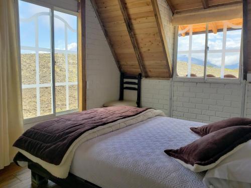 a bedroom with a large bed with two windows at Finca Masada in Mira