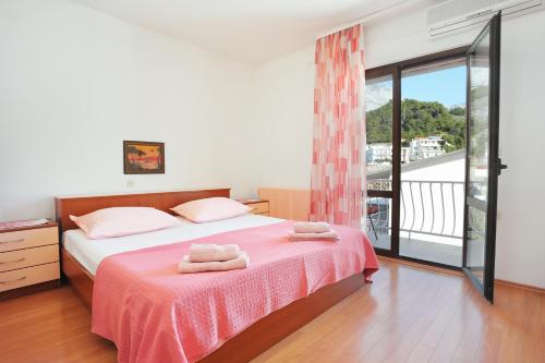a bedroom with a bed with two towels on it at Apartments by the sea Tucepi, Makarska - 2721 in Tučepi