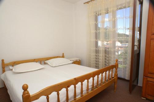 a bedroom with a bed and a large window at Apartment Drvenik Donja vala 2732a in Drvenik