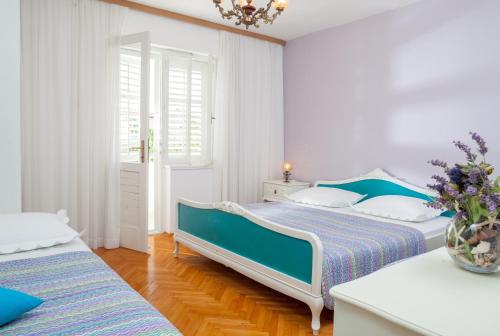 two beds in a white room with blue accents at Apartments by the sea Tucepi, Makarska - 2677 in Tučepi