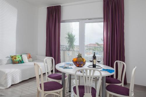 a dining room with a table and chairs and a couch at Apartments by the sea Tucepi, Makarska - 2677 in Tučepi