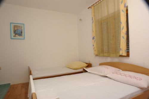 um quarto com 2 camas e uma janela em Studio Drvenik Donja vala 2732c em Drvenik