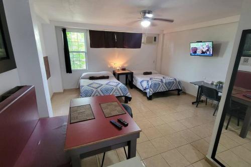 a hotel room with two beds and a table at DepaB privado, centrico,Wifi 80 mb ,aire acondicionado ,cocina, cochera techada, in Ciudad Valles
