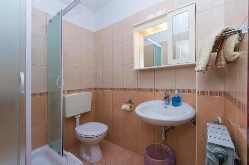 a bathroom with a toilet and a sink and a mirror at Studio Brela 2752d in Brela