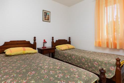 a bedroom with two beds and a window at Apartments with parking space Mimice, Omis - 2805 in Mimice