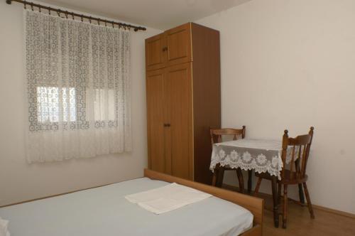 een slaapkamer met een bed, een tafel en een kast bij Apartments by the sea Orij, Omis - 2810 in Dugi Rat