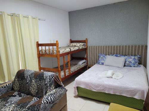 1 dormitorio con 1 cama, 1 sofá y 1 silla en Apartameto 2 quartos perto da praia e Beto Carrero, en Penha
