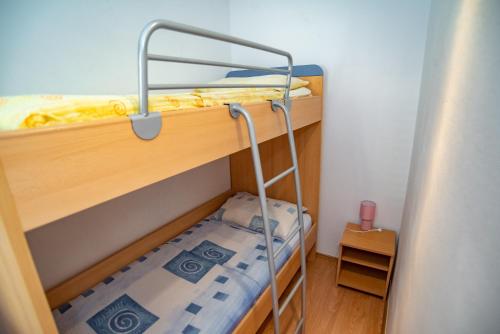 a small room with two bunk beds with a ladder at Apartment Sumpetar 2808b in Sumpetar