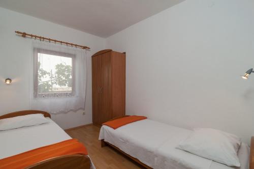 - une chambre avec 2 lits et une fenêtre dans l'établissement Apartment Postira 3065a, à Postira