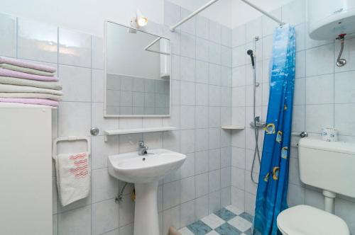 La salle de bains est pourvue d'un lavabo, de toilettes et d'un miroir. dans l'établissement Apartment Postira 3065a, à Postira