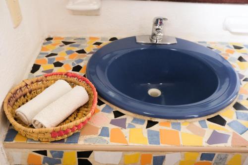 a bathroom sink with a basket of towels on a counter at Hotel Uolis Nah in Tulum