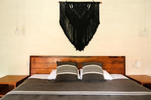 a bedroom with a bed with two pillows at Hotel Uolis Nah in Tulum