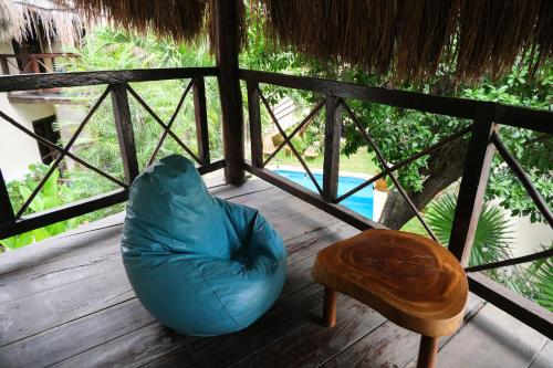 a blue bean bag chair and a table on a porch at Hotel Uolis Nah in Tulum