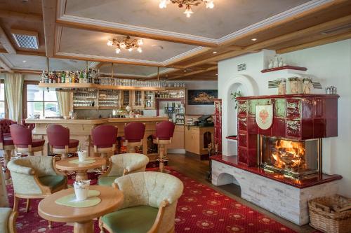 a restaurant with tables and chairs and a fireplace at Hotel Dornauhof in Finkenberg
