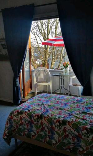 a bedroom with a bed and a table with an umbrella at Nahlboms in Sandefjord