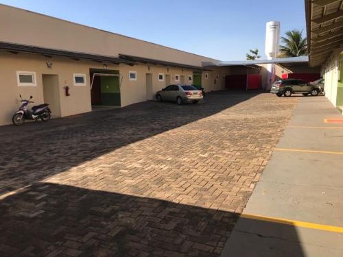 a brick parking lot with cars parked in front of a building at Motel& Hotel Apê Goiânia !!! in Goiânia