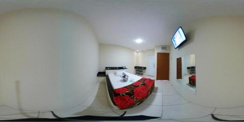 a room with a bath tub with a television on a wall at Motel& Hotel Apê Goiânia !!! in Goiânia