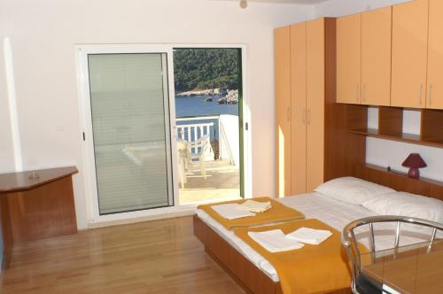 Un dormitorio con una cama y una ventana grande. en Apartments by the sea Milna, Hvar - 3074, en Hvar