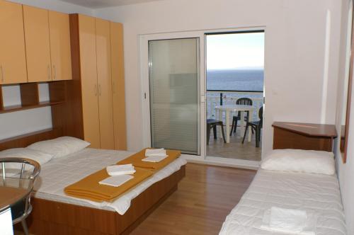 a bedroom with two beds and a view of the ocean at Studio Milna 3074c in Hvar