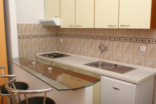 a kitchen with a sink and a counter with stools at Studio Milna 3074f in Hvar