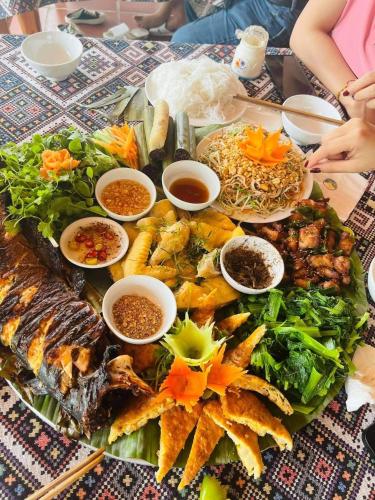a table with a bunch of different types of food at Mai Chau Sunset Boutique Hotel in Mai Chau