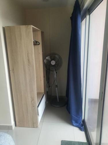 a room with a room with a fan and a window at Lovely studio condo with balcony & pool @ Suria Jelutong in Shah Alam