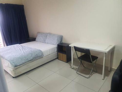 a small bedroom with a bed and a desk at Lovely studio condo with balcony & pool @ Suria Jelutong in Shah Alam