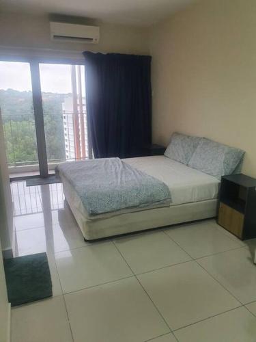 a bedroom with a bed and a large window at Lovely studio condo with balcony & pool @ Suria Jelutong in Shah Alam