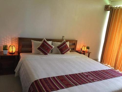 a bedroom with a large white bed with pillows at Mai Chau Sunset Boutique Hotel in Mai Chau