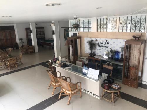 a lobby with chairs and a counter in a building at Mali's Room in Chiang Mai