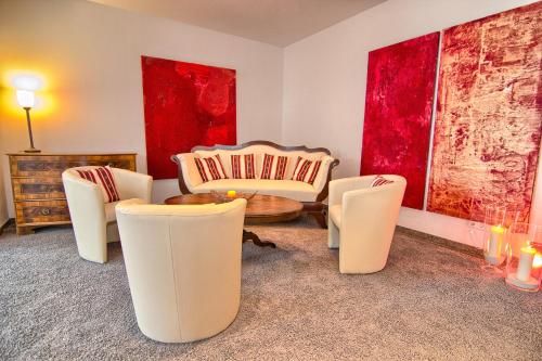 a living room with white chairs and a table at Hotel Am Froschbächel in Bühl