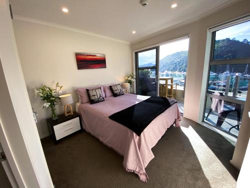 a bedroom with a bed and a large window at Two Bedroom Apartment on the water in Picton