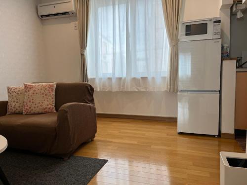 salon z kanapą i lodówką w obiekcie ＡｋＢ33 Room-2 w mieście Teine