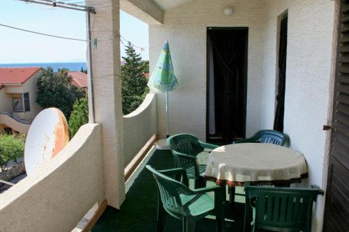 een patio met een tafel en stoelen op een balkon bij Apartment Mandre 3084c in Kolan