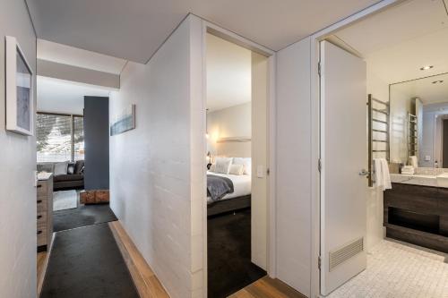 a room with a bathroom with a bed and a mirror at Silver Run Thredbo in Thredbo