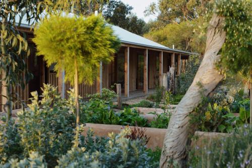 a house with a garden in front of it at TIMBA - Luxury bush retreat with pool, spa & gym in The Range