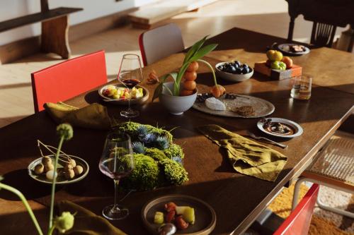 a table with plates of food and glasses of wine at TIMBA - Luxury bush retreat with pool, spa & gym in The Range