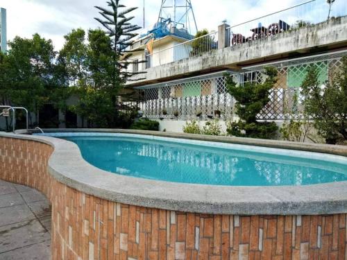 - une piscine dans un mur de briques à côté d'un bâtiment dans l'établissement Six21 FAMILY UNIT with WIFI FREE!, à Antipolo