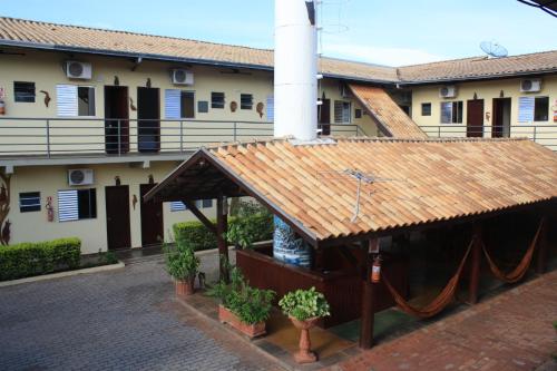 a building with a brown roof with a porch at Hotel Refugio in Bonito