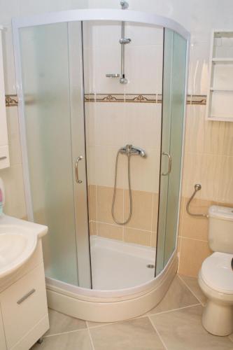a shower with a glass door in a bathroom at Double Room Rogoznica 3097a in Rogoznica