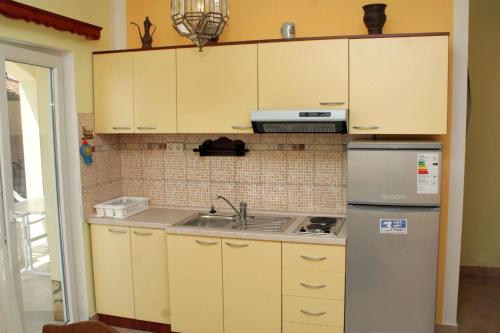 een keuken met een wastafel en een koelkast bij Apartment Rogoznica 3097a in Rogoznica