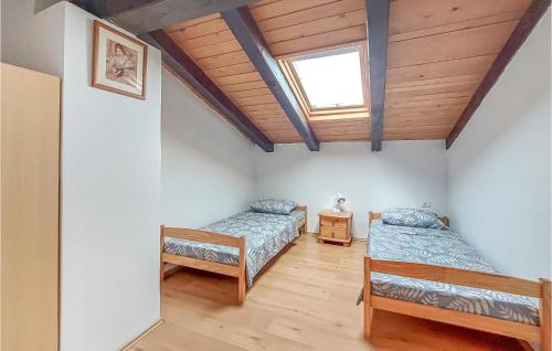 4 Bedroom Nice Home In Buzet في بوزت: غرفة نوم بسريرين ونور
