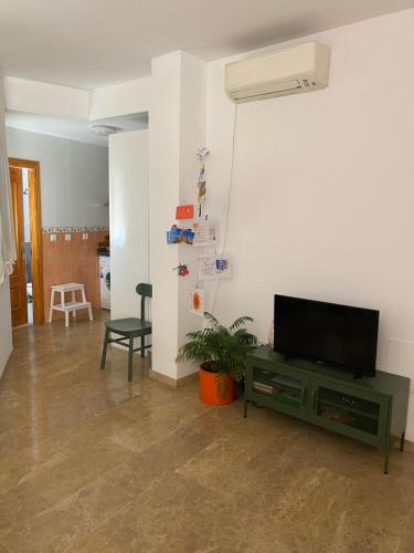 een woonkamer met een flatscreen-tv aan de muur bij Private terrace & Free Parking in Málaga