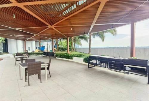 a pavilion with tables and chairs and a patio at 1719 Almas Suites Muji Studio100mbpsNetflix By STAY in Nusajaya
