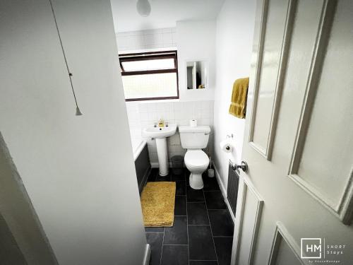 a small bathroom with a toilet and a sink at Enfield House - Beautiful 2 Bed - Good Transport Free Parking in Enfield Lock